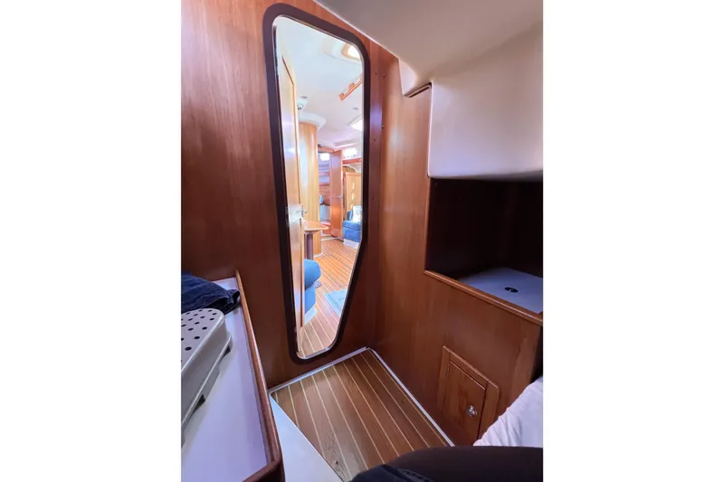 Slide: The Image of Interior of 2005 Catalina 350 sailboat, featuring wooden paneling and a mirror. - 50