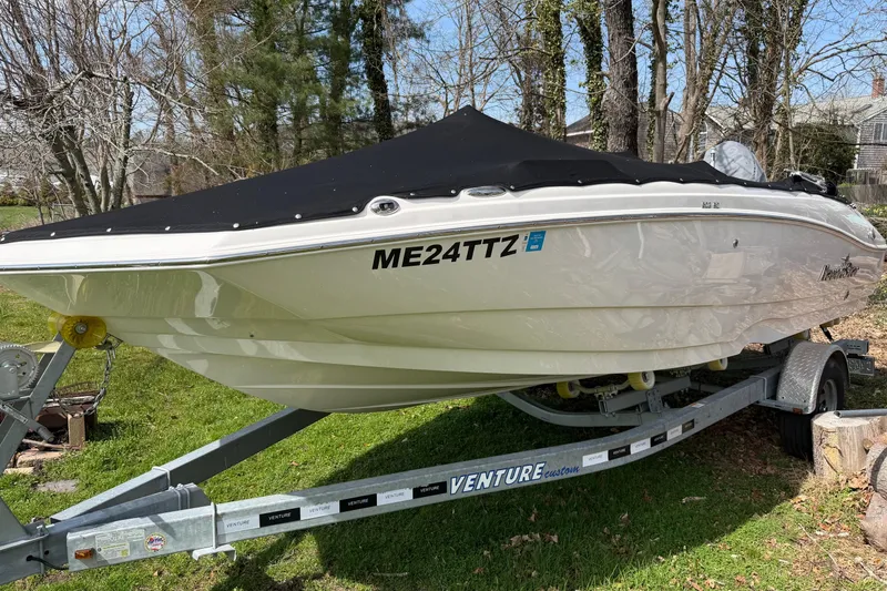 Slide: The Image of 2022 NauticStar 203 DC boat on trailer with cover, parked on grass. - 4