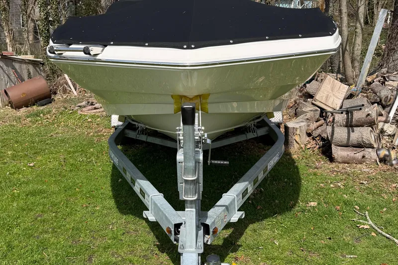 Slide: The Image of 2022 NauticStar 203 DC boat on trailer, covered, parked on grass. - 5