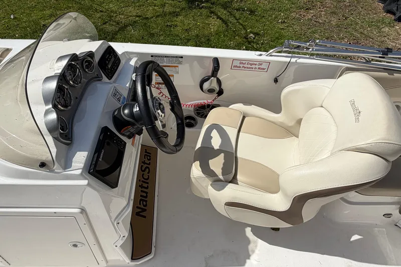Slide: The Image of 2022 NauticStar 203 DC boat cockpit with steering wheel and cushioned seat. - 8