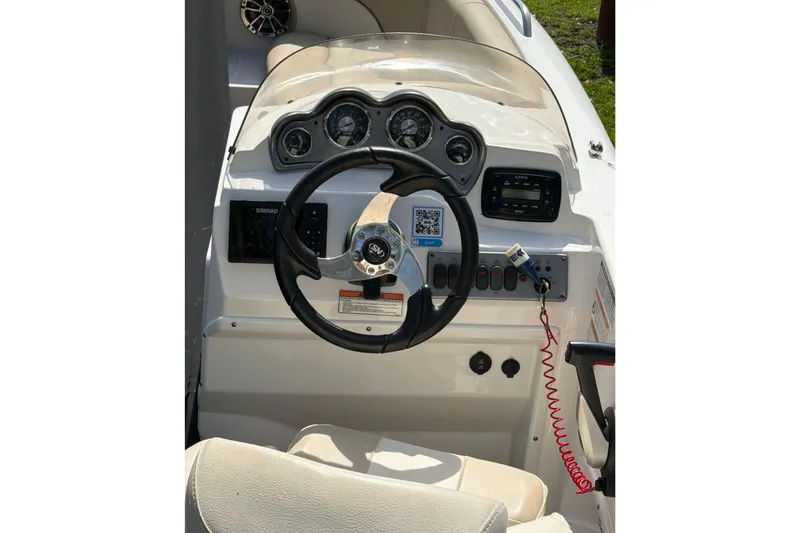 Slide: The Image of 2022 NauticStar 203 DC boat dashboard with steering wheel and control panel. - 9
