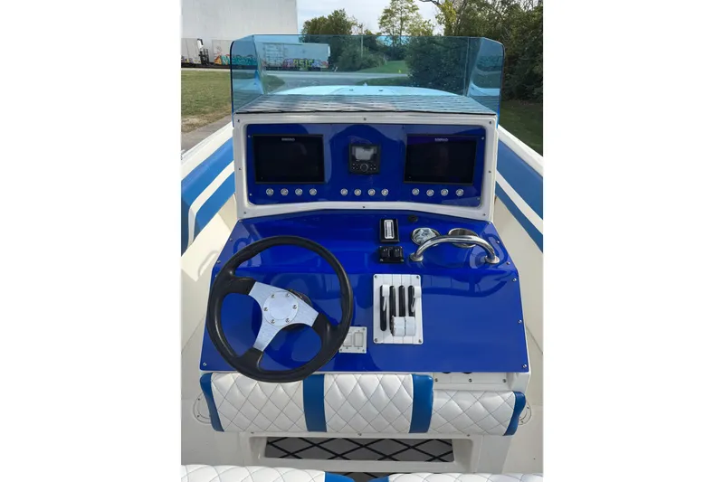 Slide: The Image of 2001 Fountain 31 Tournament Edition boat dashboard with steering wheel and navigation controls. - 16