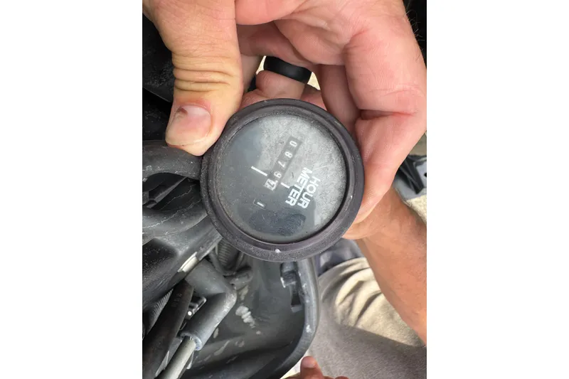 Slide: The Image of Close-up of a hand holding an hour meter from a 2001 Fountain 31 Tournament Edition boat. - 17