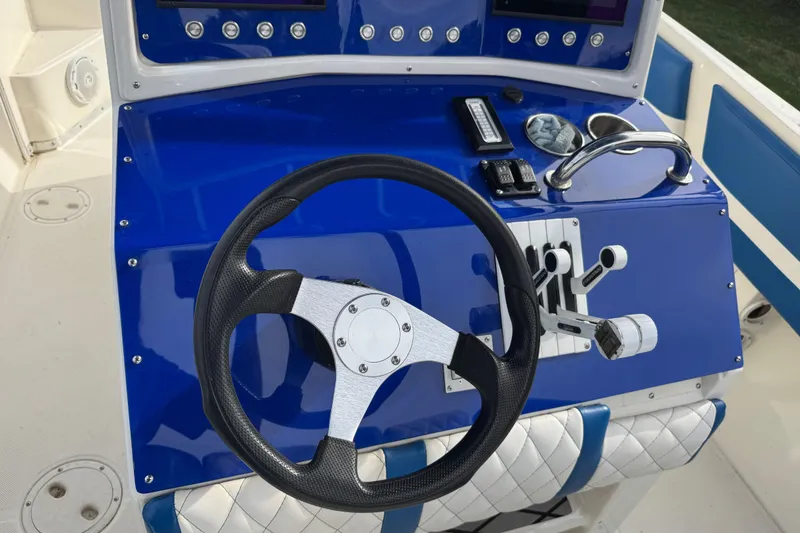 Slide: The Image of Steering console of a 2001 Fountain 31 Tournament Edition boat with blue dashboard. - 19