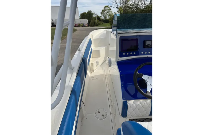 Slide: The Image of 2001 Fountain 31 Tournament Edition boat interior with blue and white seating and control panel. - 20
