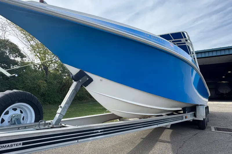 Slide: The Image of 2001 Fountain 31 Tournament Edition boat on trailer, blue hull, parked outdoors. - 3