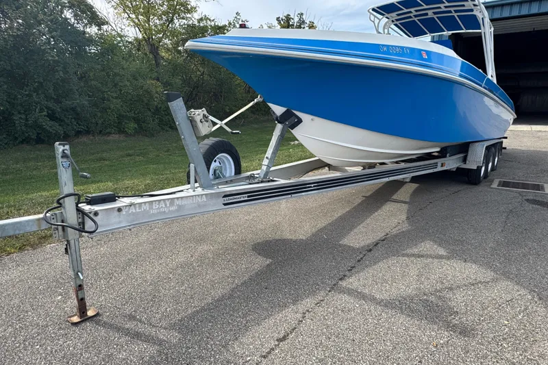 Slide: The Image of 2001 Fountain 31 Tournament Edition boat on trailer, blue hull, parked outdoors. - 5