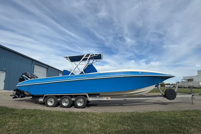 Slide: The Image of 2001 Fountain 31 Tournament Edition boat on trailer, blue hull, parked outdoors. - 8