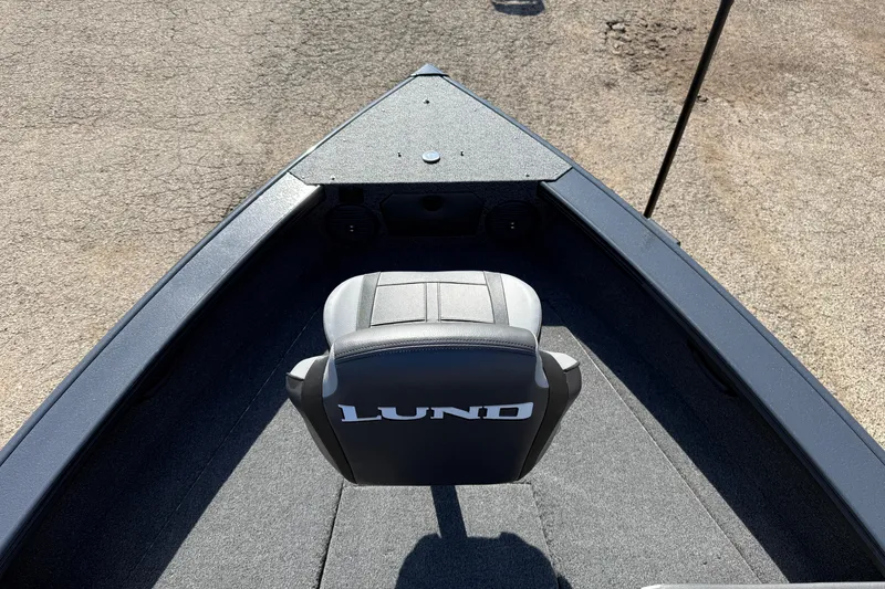 Slide: The Image of 2026 Lund 1875 Crossover XS boat interior with branded seat and carpeted flooring. - 13