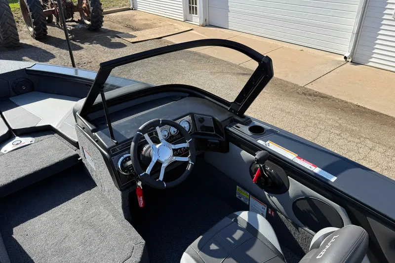 Slide: The Image of 2026 Lund 1875 Crossover XS boat interior with steering wheel and dashboard controls. - 16
