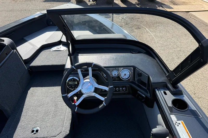 Slide: The Image of 2026 Lund 1875 Crossover XS boat interior with steering wheel and dashboard controls. - 17