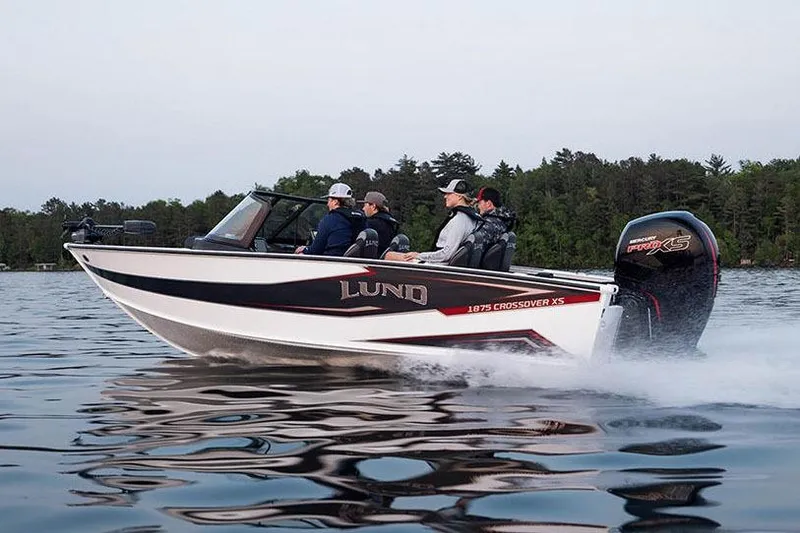 Slide: The Image of Manufacturer Provided Image: 2026 Lund 1875 Crossover XS boat cruising on a lake with passengers. - 2