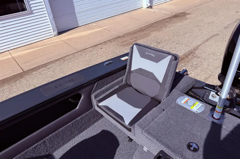 Slide: The Image of 2026 Lund 1875 Crossover XS boat seat, gray and black design, outdoor setting. - 27