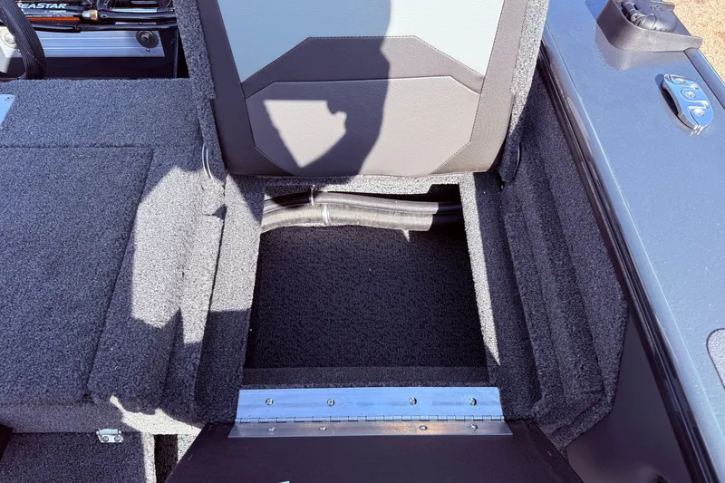 Slide: The Image of 2026 Lund 1875 Crossover XS boat interior storage compartment with carpeted finish. - 30