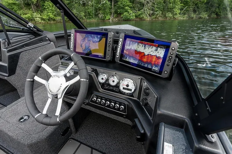 Slide: The Image of Manufacturer Provided Image: 2026 Lund 1875 Crossover XS boat dashboard with advanced navigation systems on a serene lake. - 7