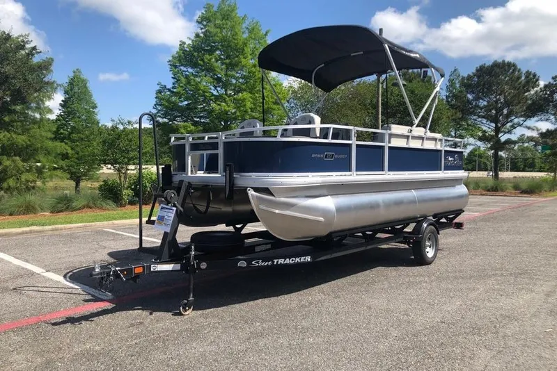 Slide: The Image of 2026 Sun Tracker Bass Buggy 18 DLX pontoon boat on trailer in parking lot. - 8