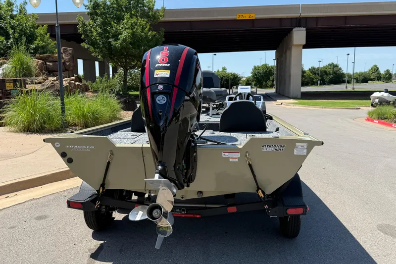 Slide: The Image of 2026 Tracker Pro Team 195 boat with powerful outboard motor, parked under a bridge. - 64