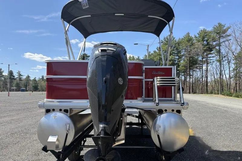 Slide: The Image of 2026 Sun Tracker Party Barge 18 DLX pontoon boat with outboard motor, parked outdoors. - 7