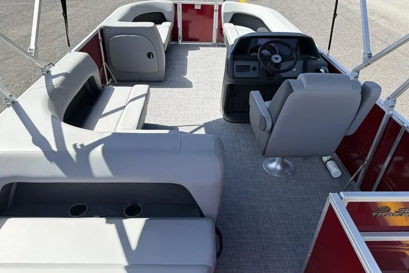 Slide: The Image of 2026 Sun Tracker Party Barge 18 DLX interior with gray seating and steering console. - 8