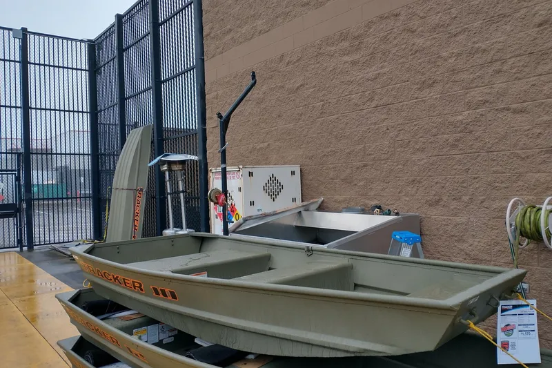 Slide: The Image of 2026 Tracker Grizzly 10 Jon boat displayed outdoors near a brick wall. - 5