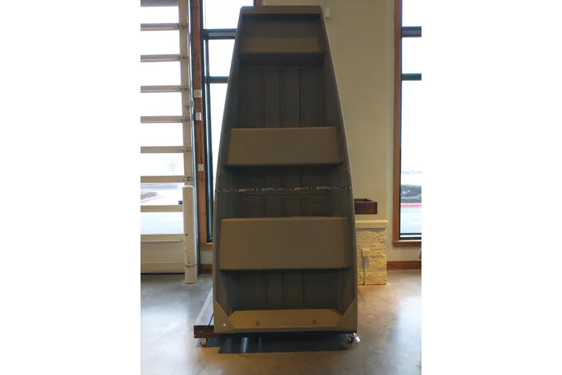 Slide: The Image of 2026 Tracker Grizzly 10 Jon boat displayed indoors, showcasing interior seating and structure. - 6