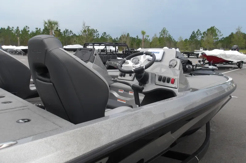 Slide: The Image of 2026 Nitro Z19 XL boat interior with steering wheel and seating, parked outdoors. - 6