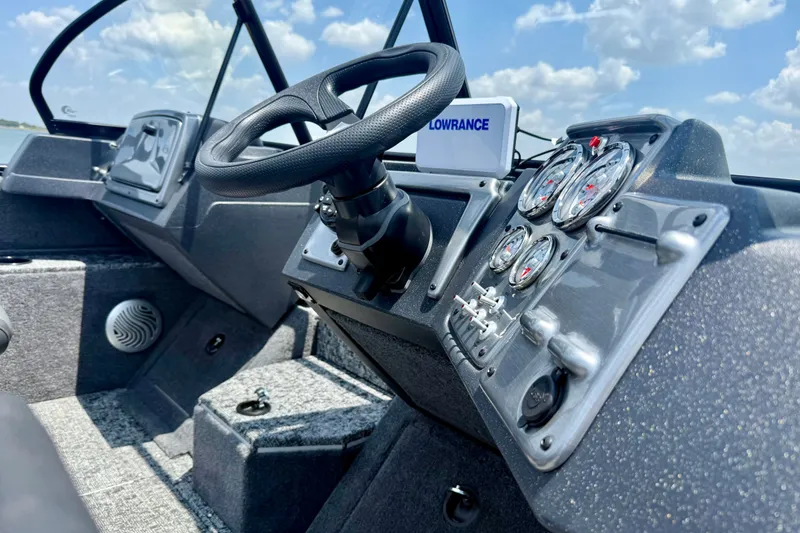Slide: The Image of Interior view of 2026 Tracker Pro Guide V-175 WT boat dashboard with steering wheel and gauges. - 2