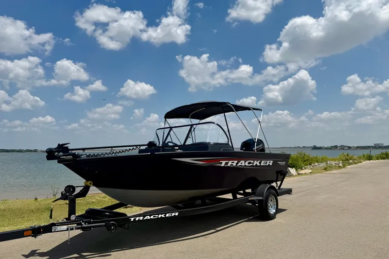 Slide: The Image of 2026 Tracker Pro Guide V-175 WT boat on trailer by a lake under a blue sky. - 22