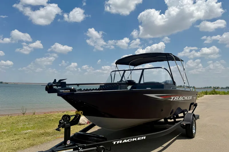 Slide: The Image of 2026 Tracker Pro Guide V-175 WT boat on trailer by a lake under a cloudy sky. - 25