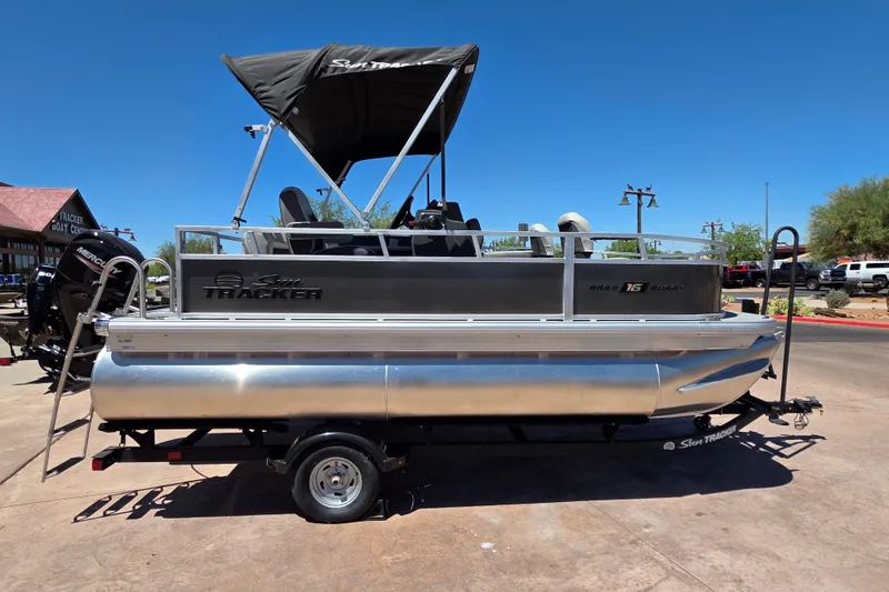 Slide: The Image of 2026 Sun Tracker Bass Buggy 16 XL Select pontoon boat on trailer, outdoor display. - 1