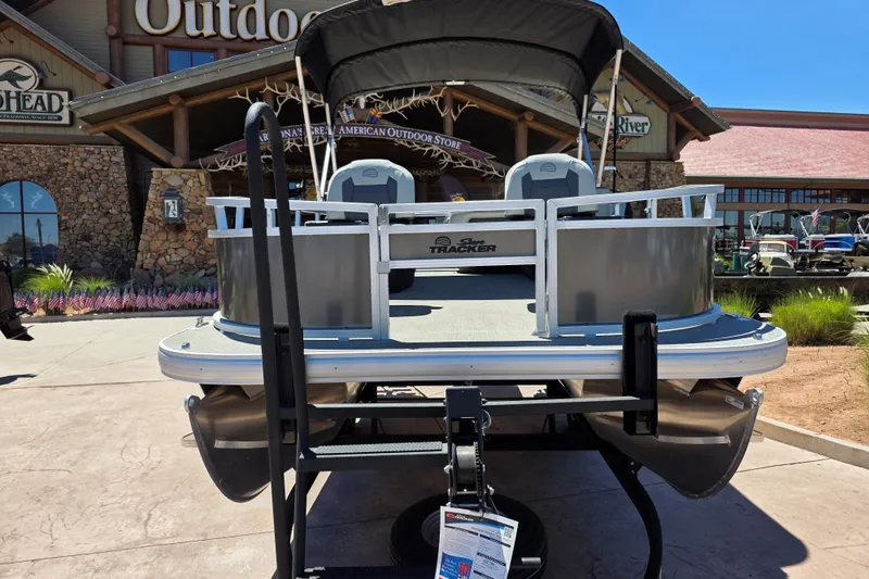 Slide: The Image of 2026 Sun Tracker Bass Buggy 16 XL Select pontoon boat displayed outdoors. - 2