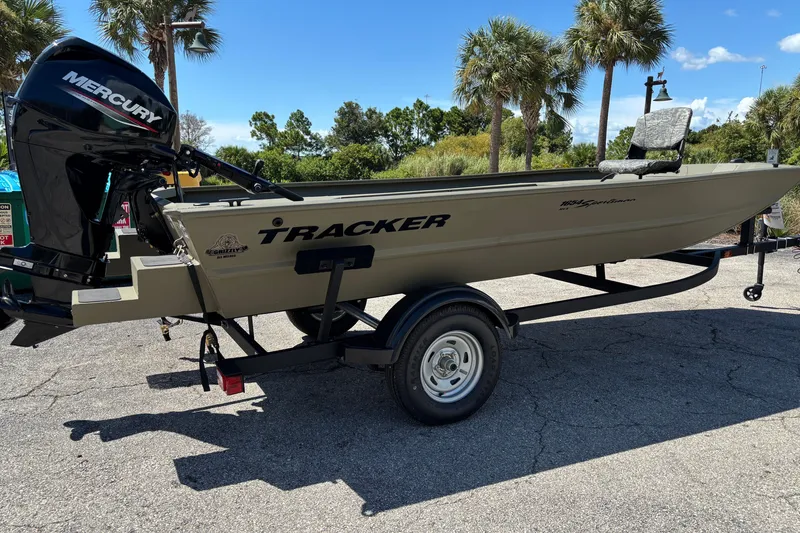 The Image of 2026 Tracker Grizzly 1654 T Sportsman boat with Mercury engine on trailer, parked outdoors. - 0
