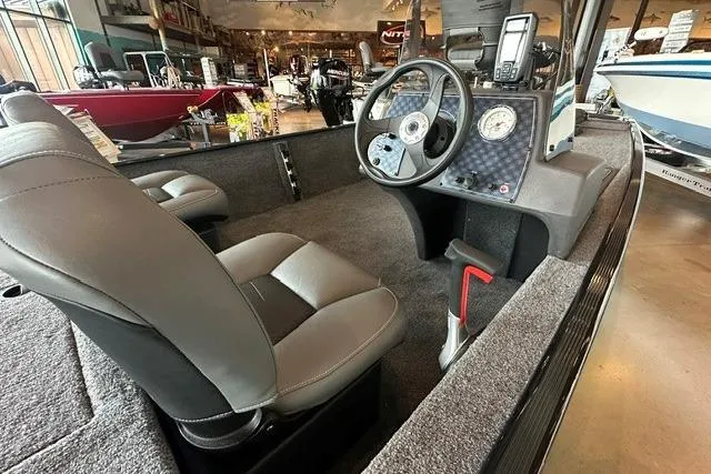Slide: The Image of 2026 Tracker Bass Tracker Classic XL boat interior with steering wheel and seating. - 9