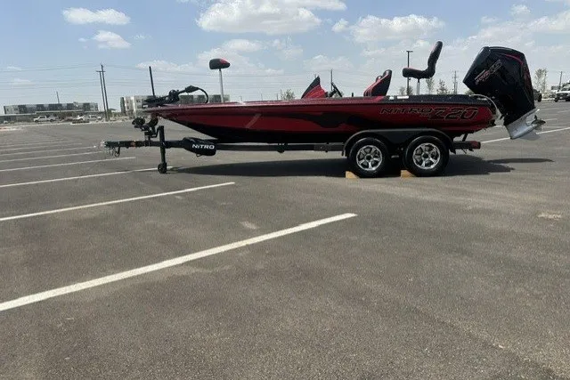 The Image of 2026 Nitro Z20 XL boat on trailer in parking lot under blue sky. - 0