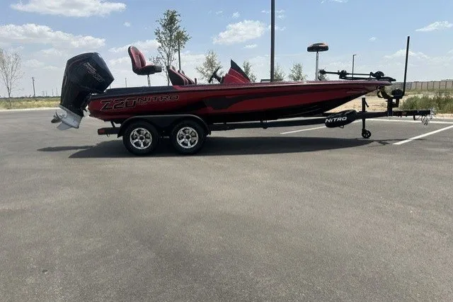 The Image of 2026 Nitro Z20 XL boat in parking lot, red and black design, dual-axle trailer. - 0