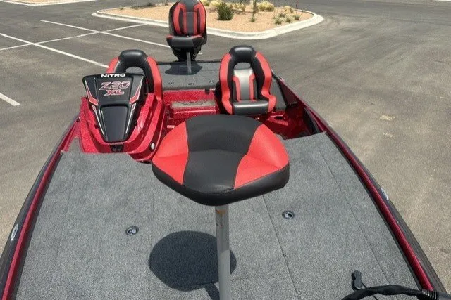 Slide: The Image of 2026 Nitro Z20 XL boat interior with red and black seating in a parking lot. - 14