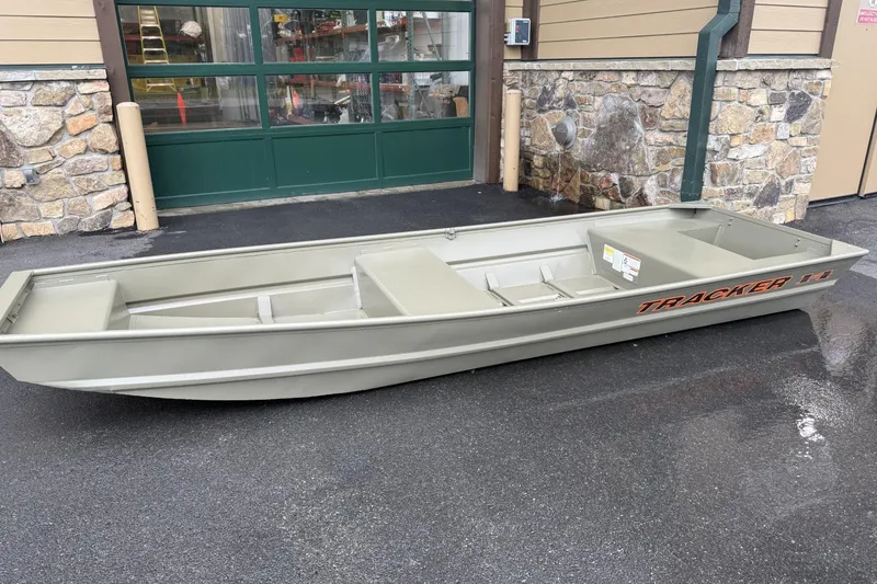 The Image of 2026 Tracker Grizzly 14 Jon boat displayed outdoors on wet pavement. - 0