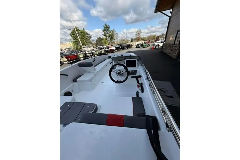 Slide: The Image of 2026 Tahoe T18 boat interior with steering wheel and seating, under a partly cloudy sky. - 66