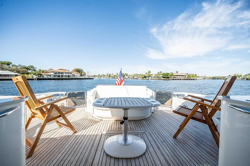 Slide: The Image of 2012 Sea Ray 610 Sundancer yacht deck with chairs, table, and scenic water view. - 4