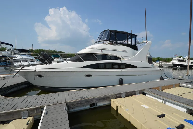 The Image of 2004 Carver 420 Mariner yacht docked at a marina under a clear blue sky. - 0
