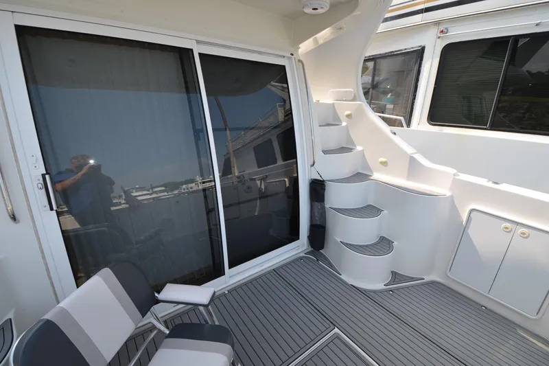 Slide: The Image of 2004 Carver 420 Mariner yacht deck with seating and stairs, featuring sleek design. - 11