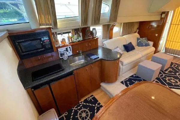 Slide: The Image of Luxurious interior of 2004 Carver 420 Mariner yacht with kitchenette and seating area. - 23