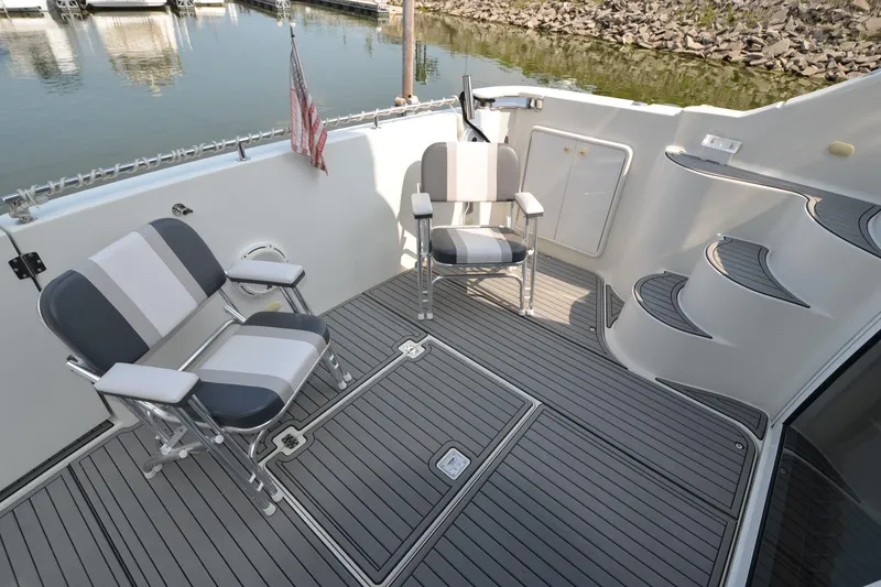 Slide: The Image of 2004 Carver 420 Mariner deck with chairs, docked by water. - 4
