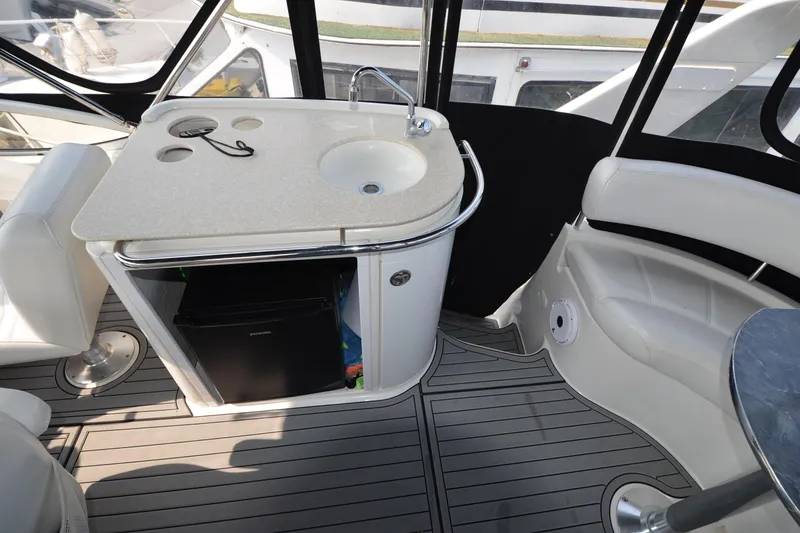 Slide: The Image of 2004 Carver 420 Mariner yacht interior with sink, mini fridge, and seating area. - 7