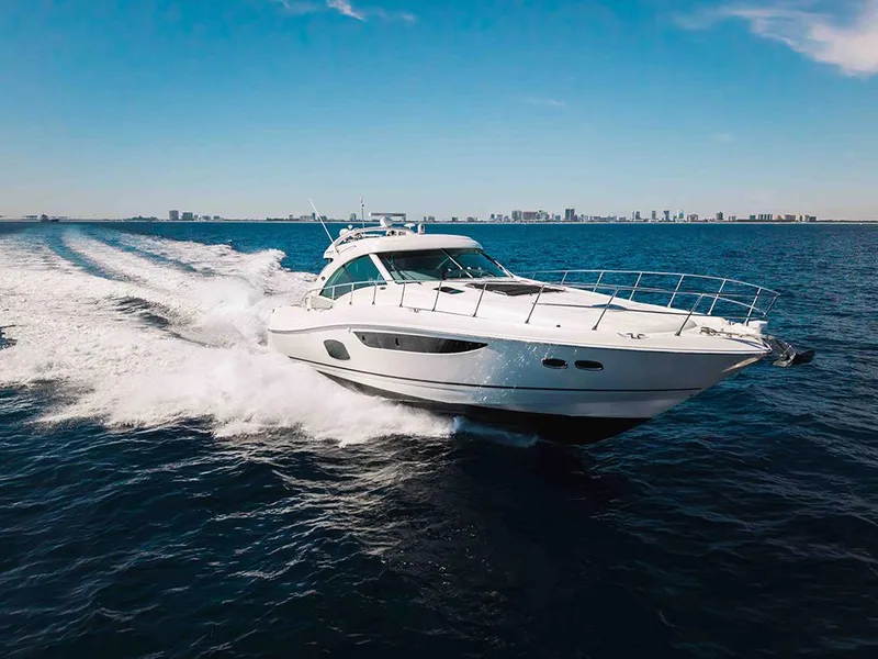 The Image of 2012 Sea Ray 610 Sundancer yacht cruising on open water, city skyline in background. - 0