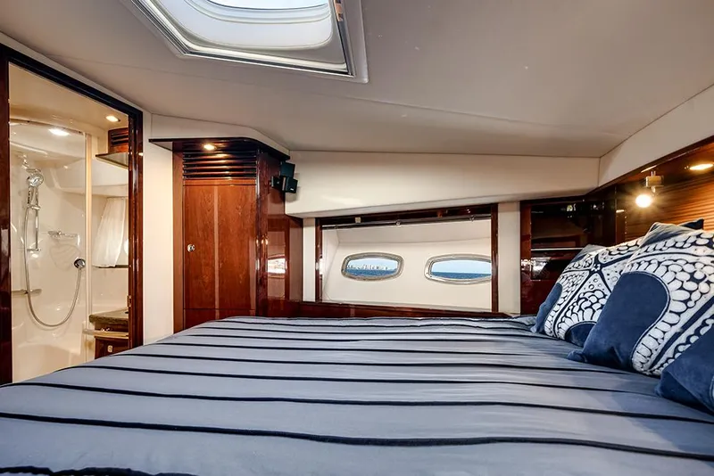 Slide: The Image of Luxurious cabin interior of 2012 Sea Ray 610 Sundancer yacht with elegant bedding and ensuite bathroom. - 39