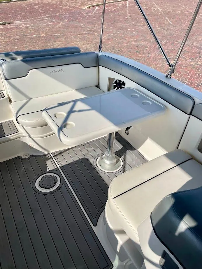 Slide: The Image of 2010 Sea Ray 300 Sundeck interior with seating and table, featuring sleek design and cup holders. - 14