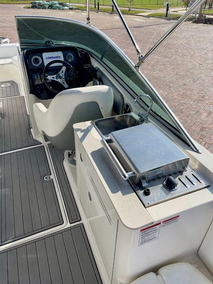 Slide: The Image of 2010 Sea Ray 300 Sundeck boat interior with helm, grill, and seating area. - 17