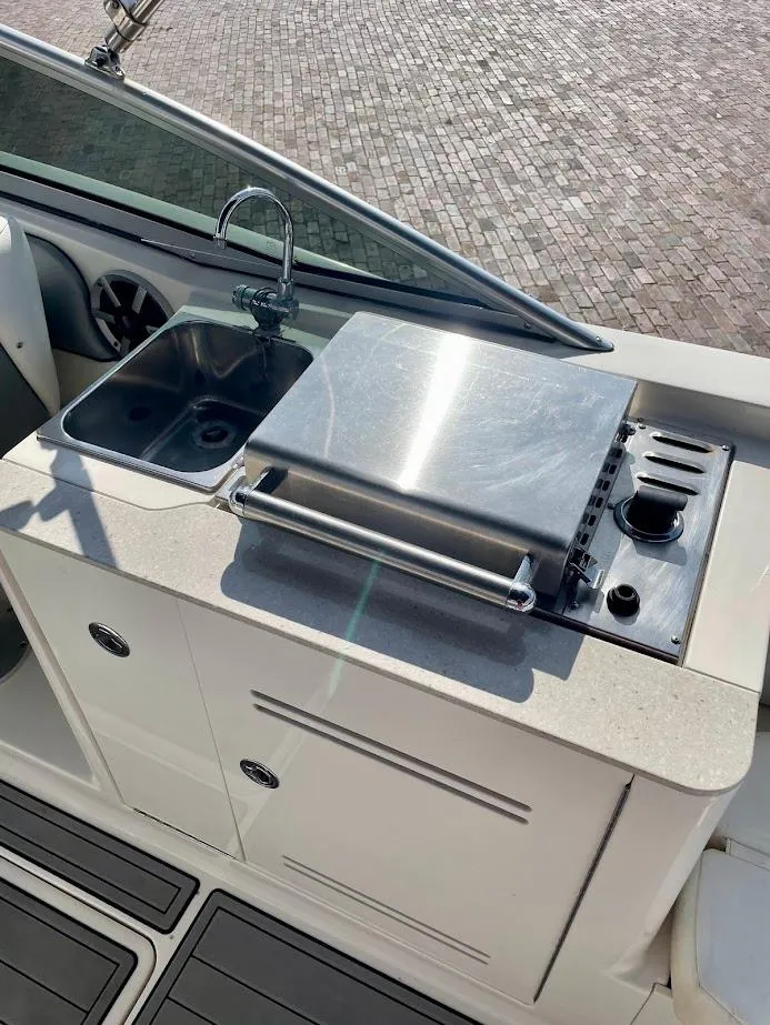 Slide: The Image of 2010 Sea Ray 300 Sundeck boat kitchen with sink and grill. - 18
