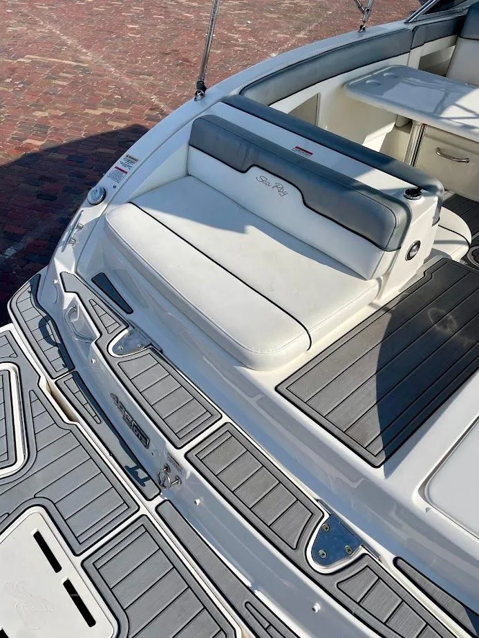 Slide: The Image of 2010 Sea Ray 300 Sundeck boat with cushioned seating and sleek deck design. - 22